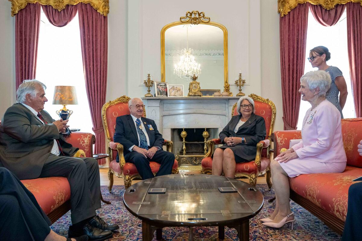Le gouverneur général est assis sur une chaise avec Son Honneur l'honorable Arthur J. LeBlanc, lieutenant-gouverneur de la Nouvelle-Écosse