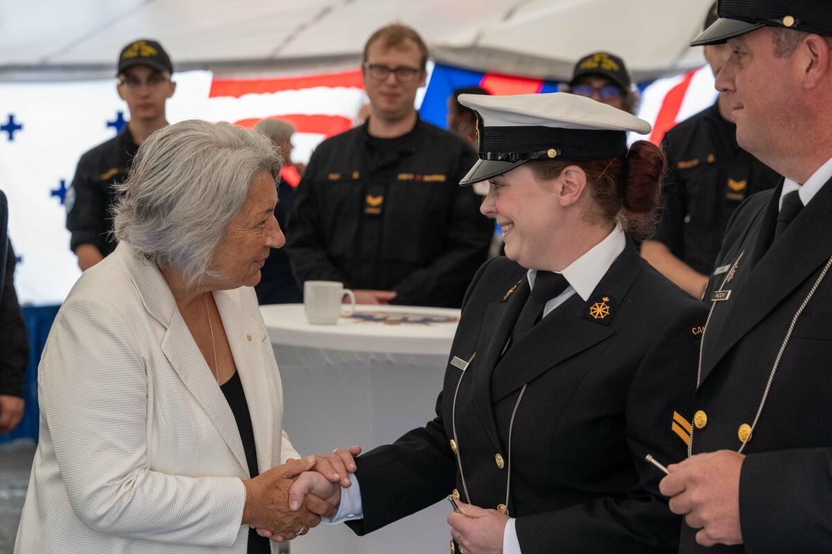 La gouverneure générale Mary Simon serre la main d'un membre de la Marine royale canadienne.