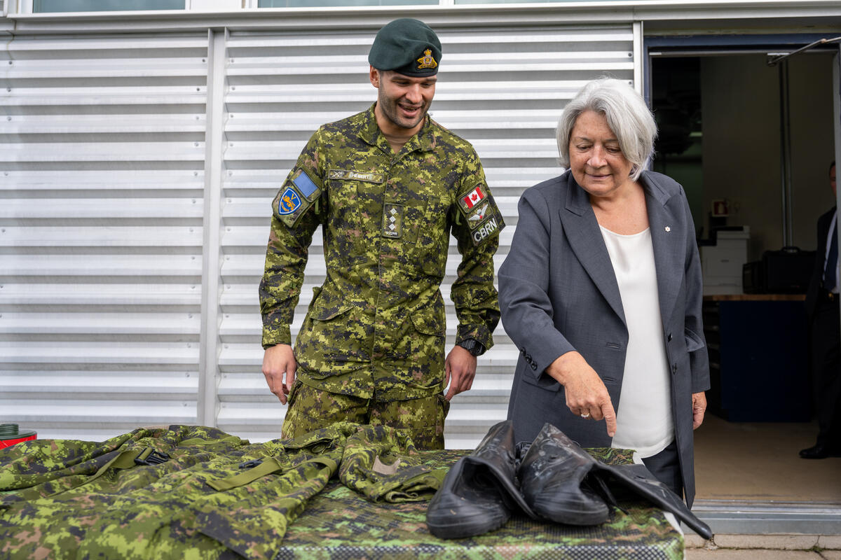 La gouverneure générale Mary Simon examine l'équipement de décontamination avec un capitaine de l'Armée canadienne