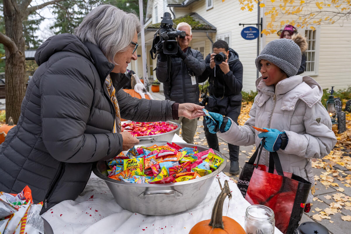 La gouverneure générale Mary Simon distribue des bonbons à un enfant déguisé