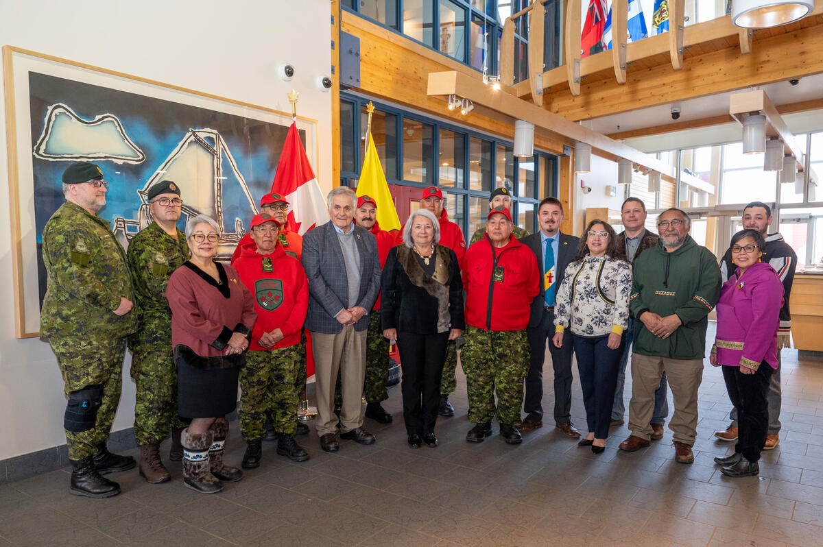 GG Simon se tient aux côtés des membres de son accueil officiel, qui comprennent des Rangers canadiens, des membres des Forces armées canadiennes et des dirigeants communautaires