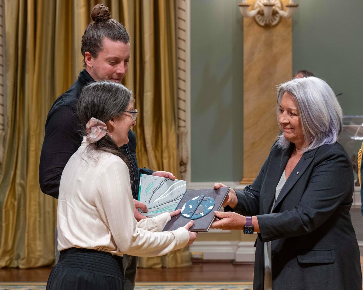 Governor General Mary Simon hands over a GG Literary Award to a recipient