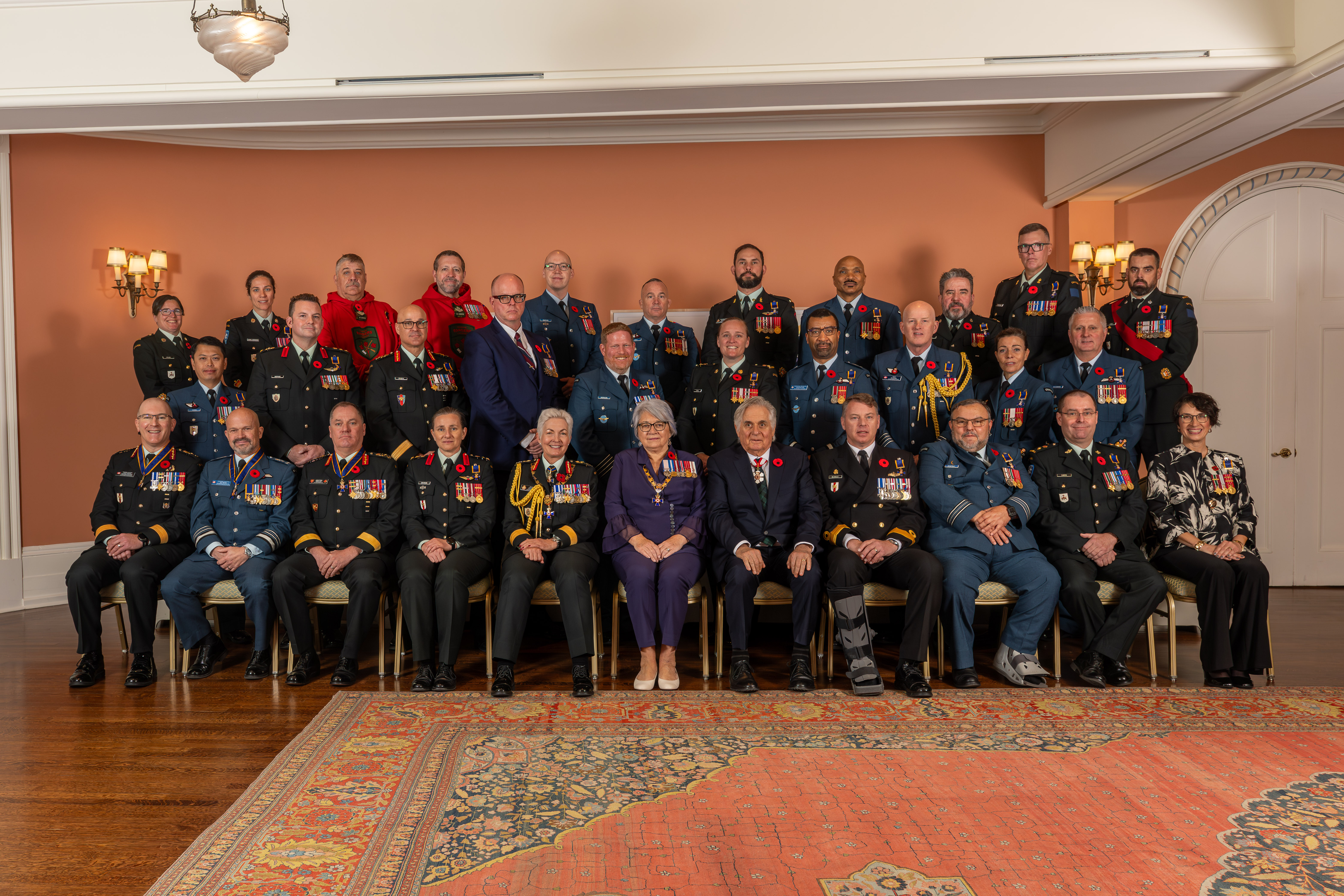 La gouverneure générale Simon et des membres des Forces armées canadiennes suivant une cérémonie de remise de l'Ordre du mérite militaire.