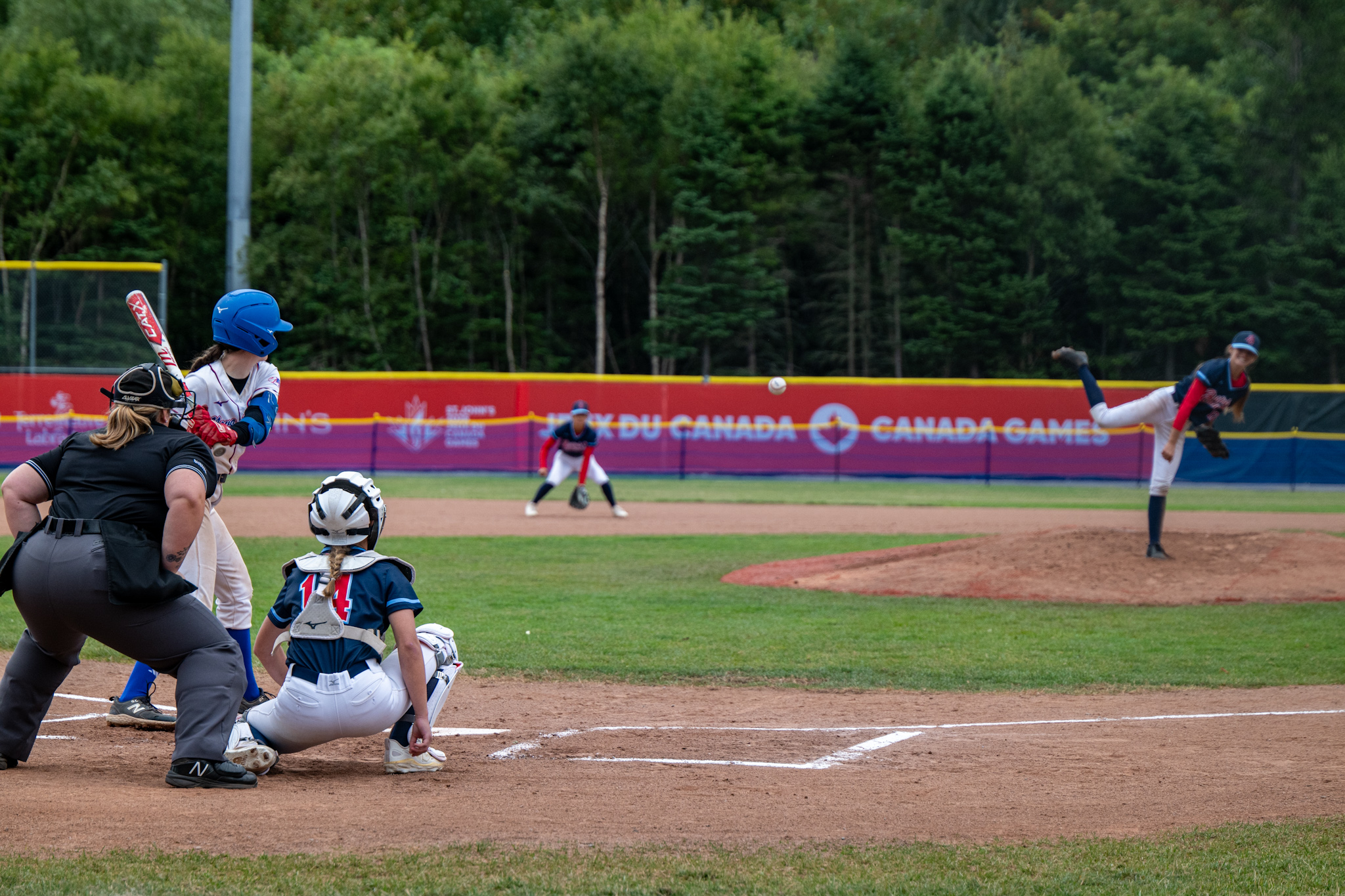 Un lanceur qui vient de lancer une balle de baseball vers le marbre.