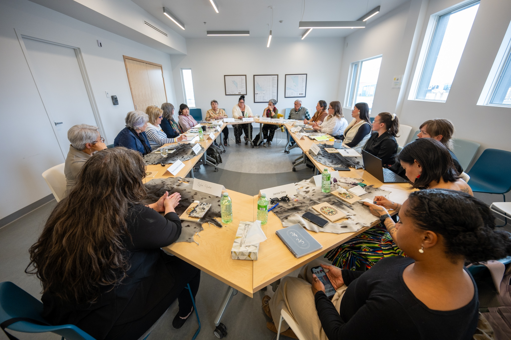 Several people seated at tables, engaging in a round-table discussion.