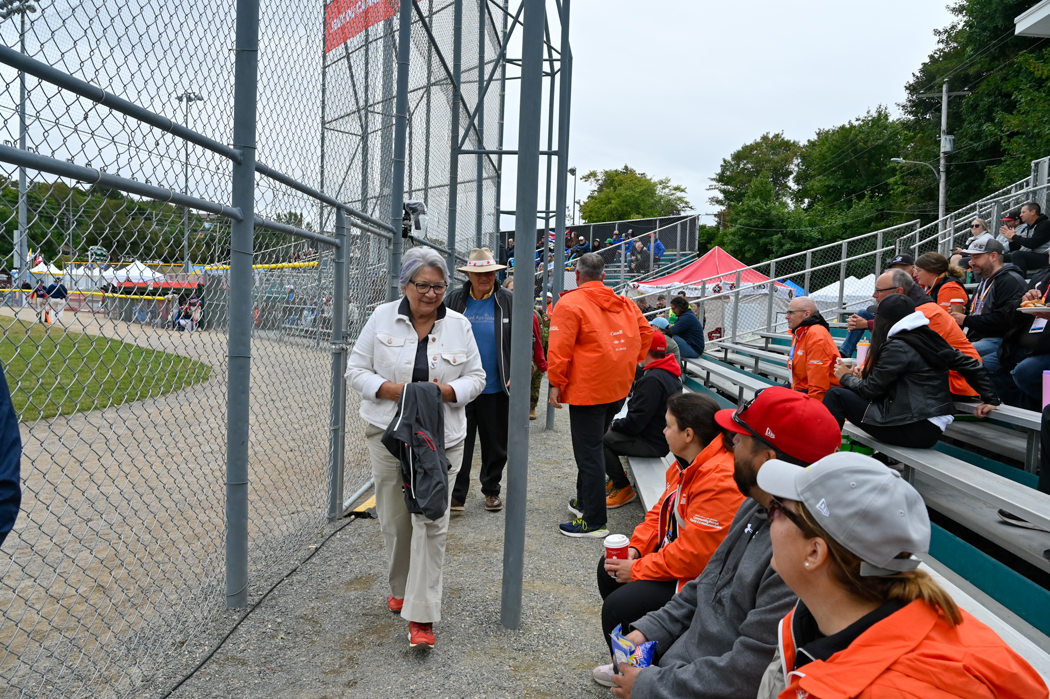 La gouverneure générale Mary Simon marchant près d'un groupe de personnes assises dans les gradins lors d'un match de baseball.