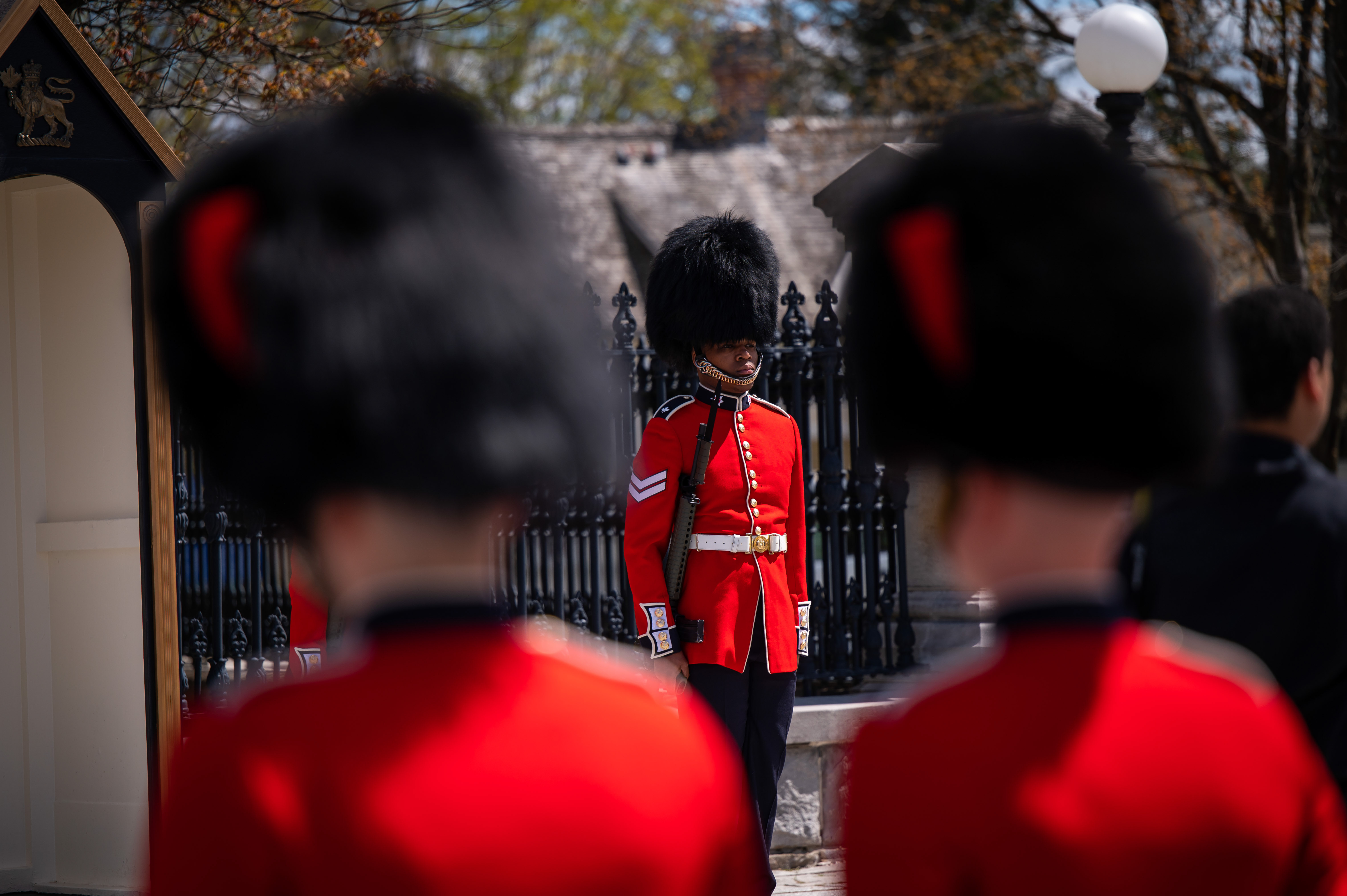 Members of the Governor General Foot Guards stand at attention at the Queens Gate at Rideau Hall