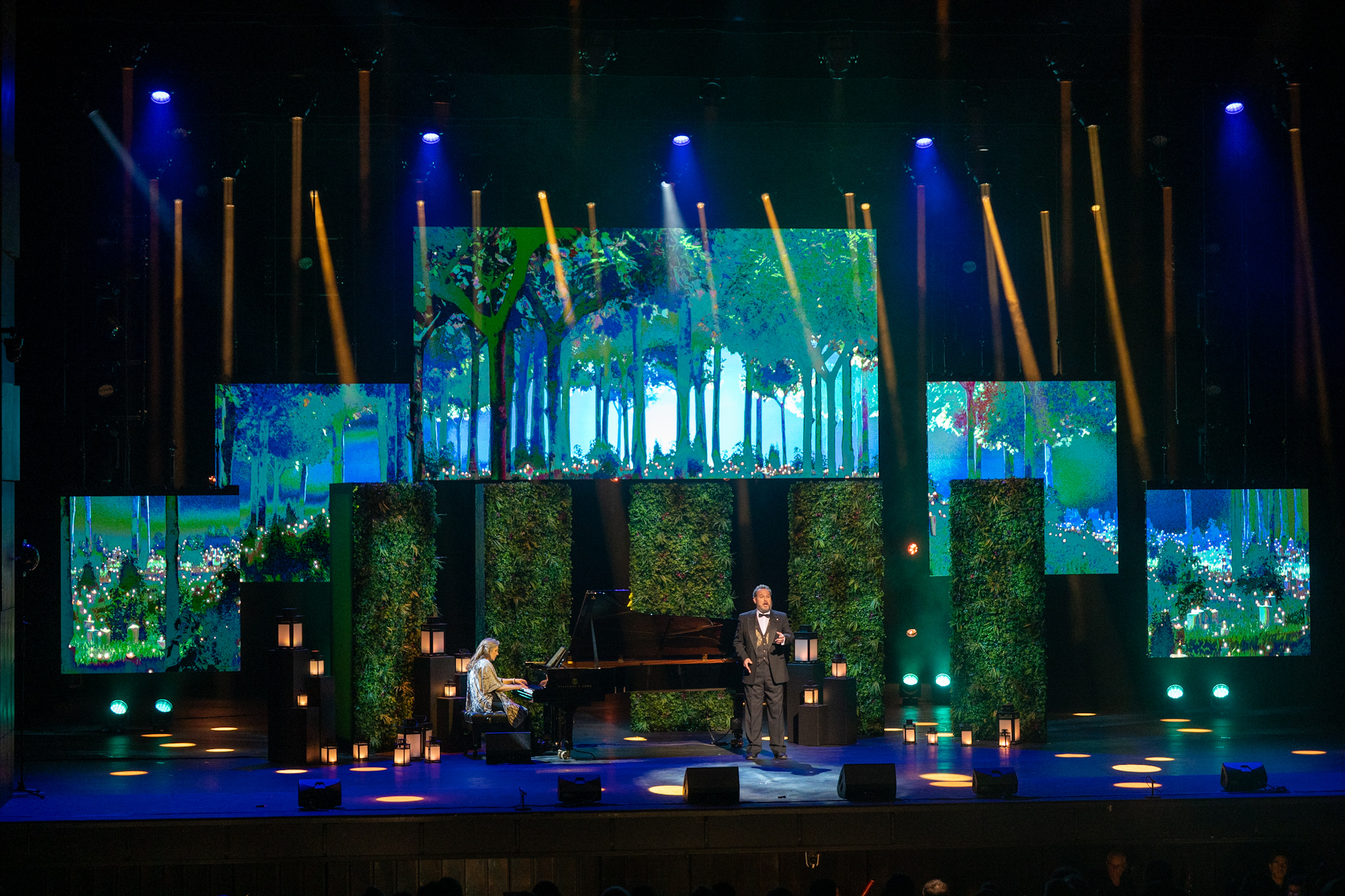 Un pianiste et une autre personne sont sur scène au Centre National des Arts dans le cadre de la cérémonie des Prix du Gouverneur général pour les arts du spectacle. Plusieurs lanternes, des écrans et des toiles de fond vertes sont disposés sur la scène.