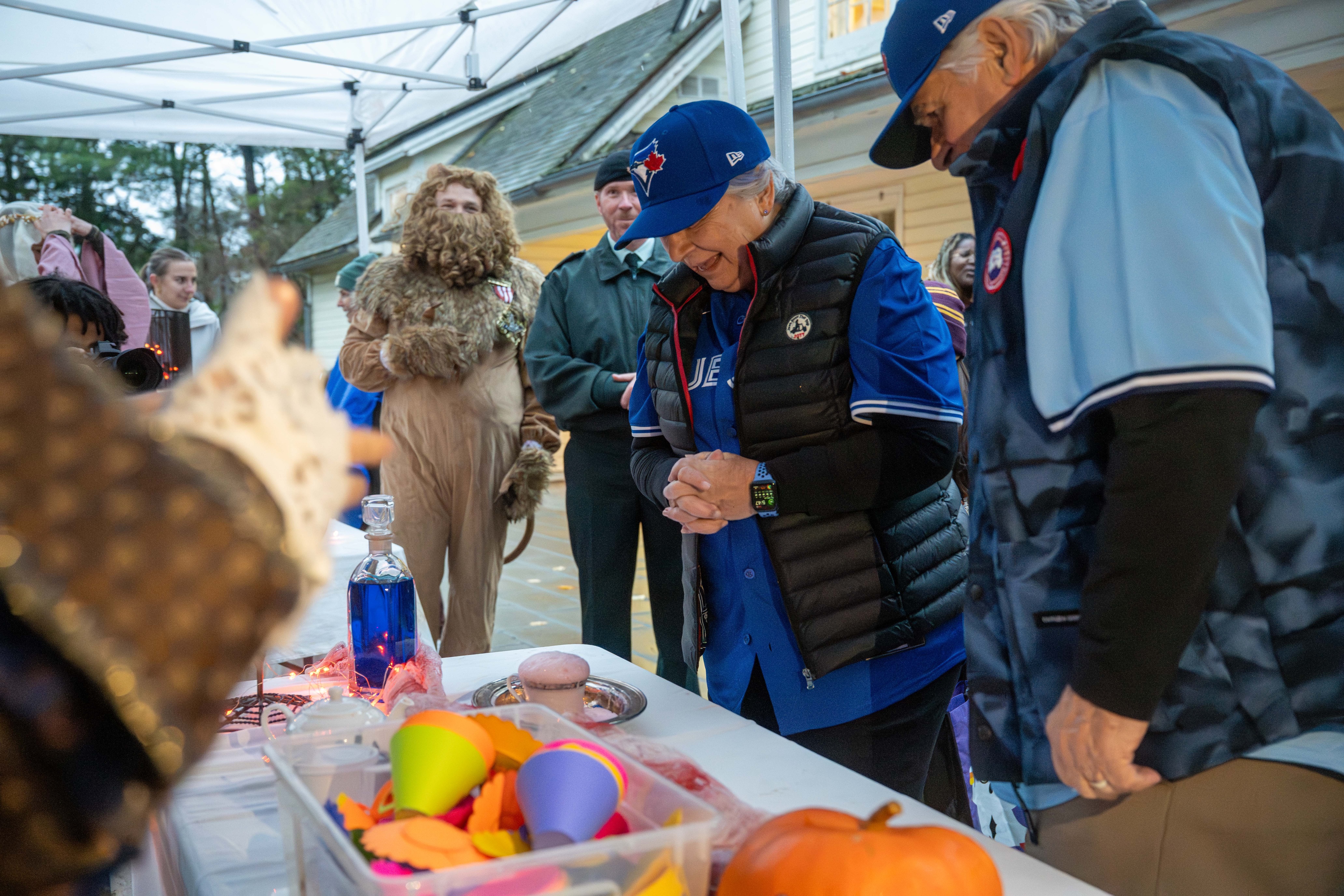La gouverneure générale Mary Simon, déguisée en Blue Jays pour Halloween, sourit à un jeune enfant venu chercher des bonbons.