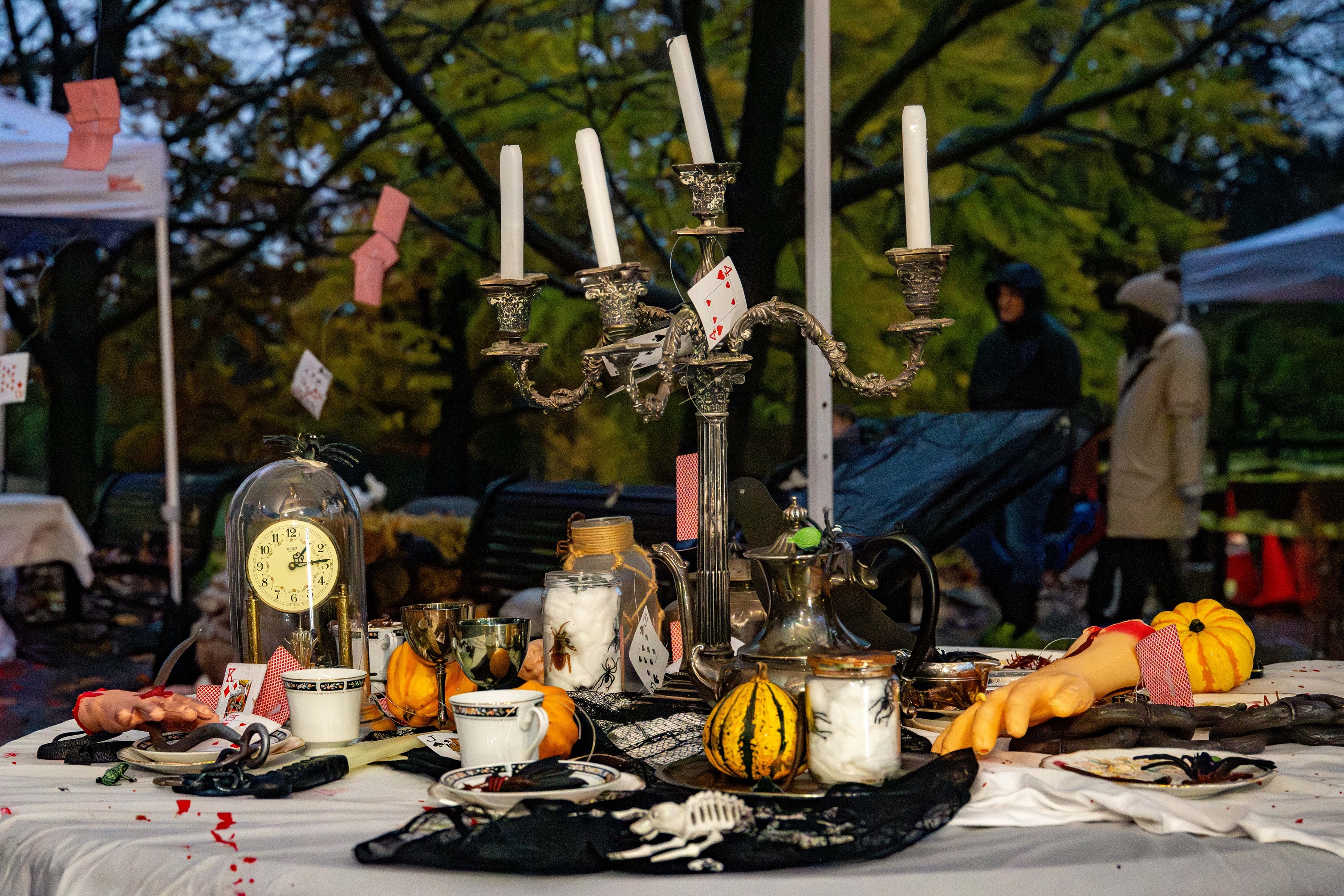 Thé sur le thème d'Halloween servi sur une nappe blanche décorée de squelettes et d'araignées.