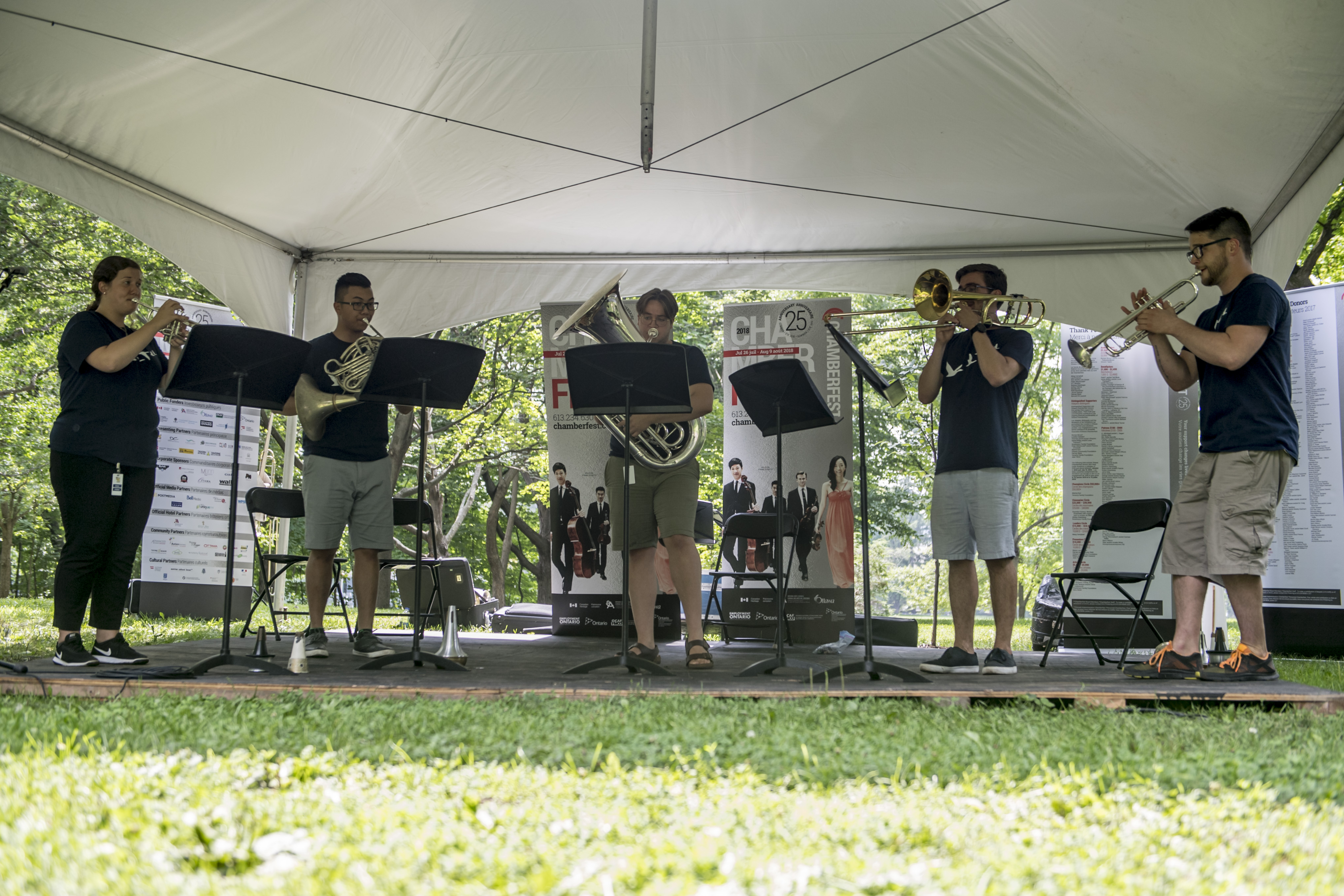 Five young musicians play their brass instruments on the grounds of Rideau Hall.