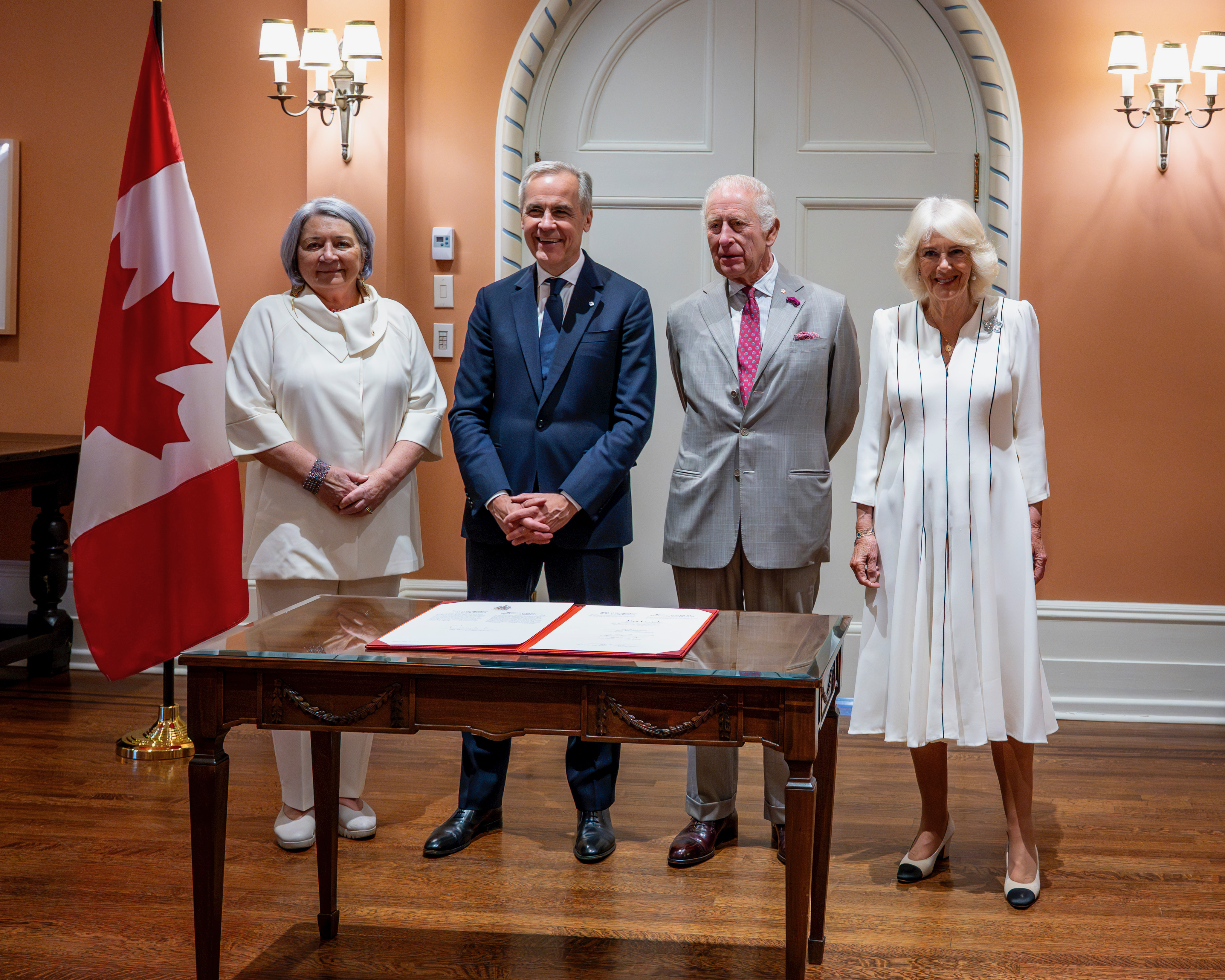 La gouverneure générale Mary Simon, le premier ministre Mark Carney et Leurs Majestés devant une table.