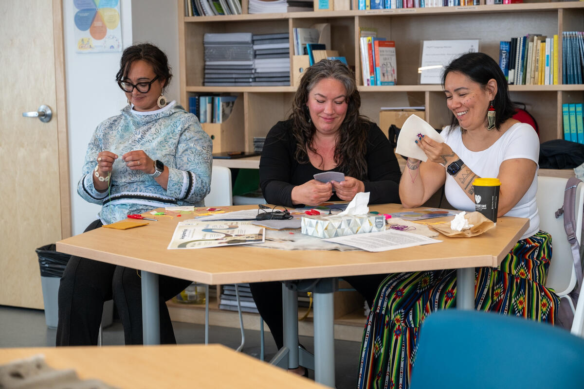 Trois personnes souriantes participant à un atelier au centre de bien-être communautaire d'Inuusirvik.
