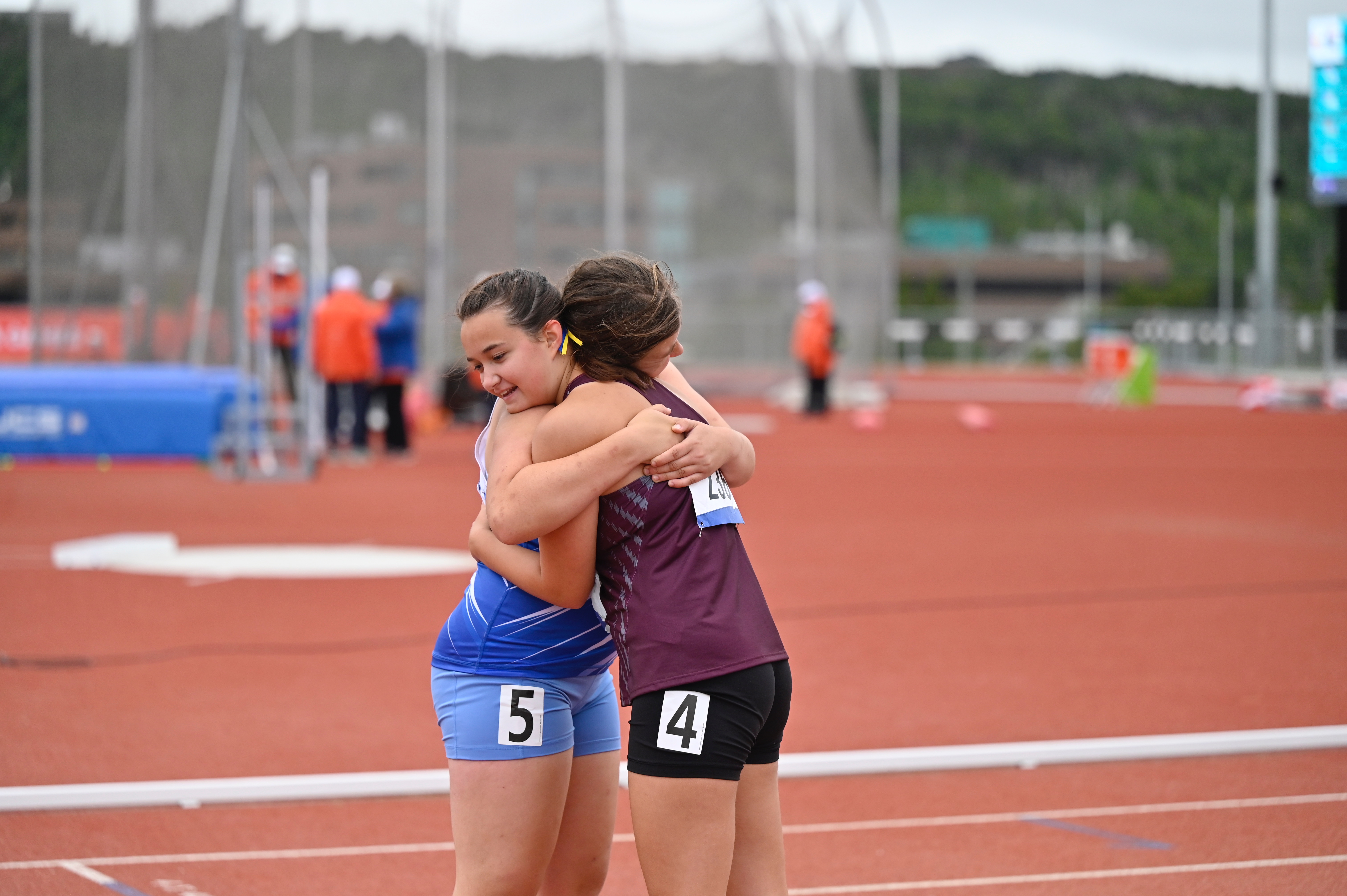 Deux athlètes s'étreignant sur une piste d'athlétisme.