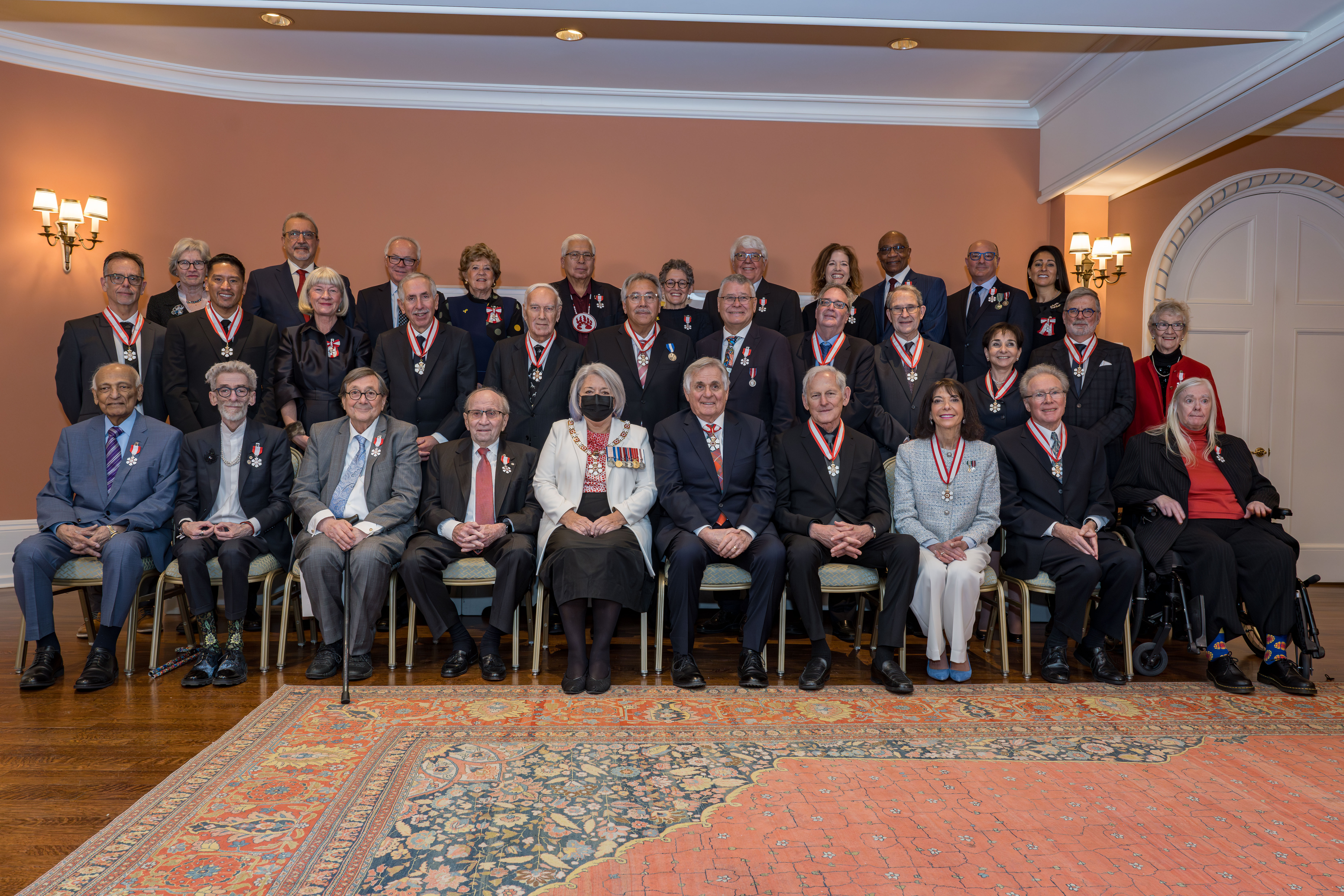 La gouverneure générale Simon et M. White Fraser assis au centre d'une photo de groupe montrant des membres de l'Ordre du Canada.