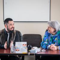 The Governor General and the Mayor of Kangiqsualujjuaq are sitting at a table.