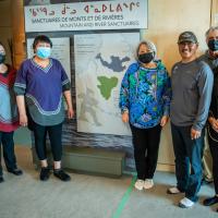 The Governor General is posing for a picture by a sign for the Kuururjuaq National Park Interpretation Centre.
