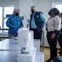 Their Excellencies are getting a tour. There is a sewing machine in the foreground.