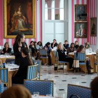 A group of women engage in conversation with Governor General Simon, in the Tent Room at Rideau Hall.