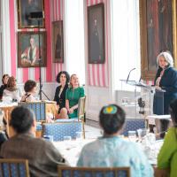A group of women engage in conversation with Governor General Simon, in the Tent Room at Rideau Hall.
