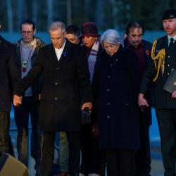 La gouverneure générale Mary Simon, le premier ministre du Canada Mark Carney et le chef du parti de l’opposition officielle du Canada Pierre Poilievre, debout main dans la main. Des personnes se tiennent derrière eux.