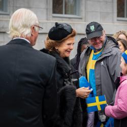 Leurs Majestés le roi Carl XVI Gustaf et la reine Silvia de Suède saluent une jeune fille dans une petite foule devant Rideau Hall.