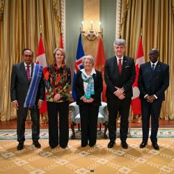 La gouverneure générale Mary Simon avec quatre nouveaux chefs de mission. Les drapeaux de chaque pays se trouvent derrière eux. Deux gardes d'honneur se trouvent à l'arrière.