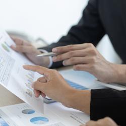 Close up of two people looking at spreadsheets