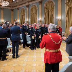 La gouverneure générale Mary Simon et un groupe de personnes se tenant dans la salle de bal de Rideau Hall, en train d'applaudir.