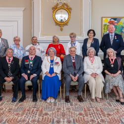 La gouverneure générale Mary Simon et M. Whit Fraser posent pour une photo de groupe avec les récipiendaires de l'Ordre du Canada.