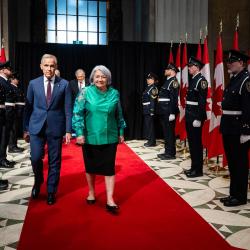 La gouverneure générale Mary Simon et le premier ministre Mark Carney marchant sur un tapis rouge.