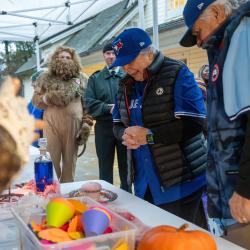 La gouverneure générale Mary Simon, déguisée en Blue Jays pour Halloween, sourit à un jeune enfant venu chercher des bonbons.
