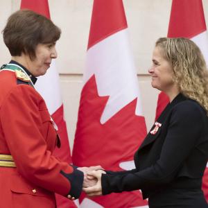 Shirley Cuillierrier is shaking hands with the Governor General.