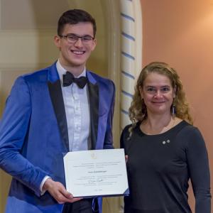 Sven Stammberger tient son certificat et pose pour une photo aux côtés de la gouverneure générale.