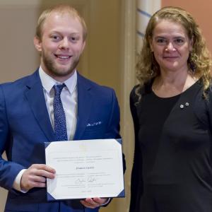 Francis Carter tient son certificat et pose pour une photo aux côtés de la gouverneure générale.