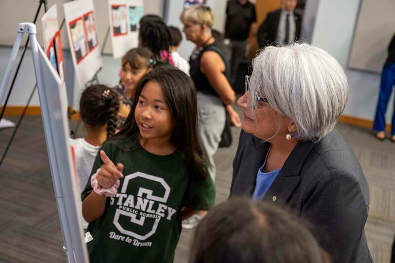 Governor General Mary Simon looks at projects with on of the children