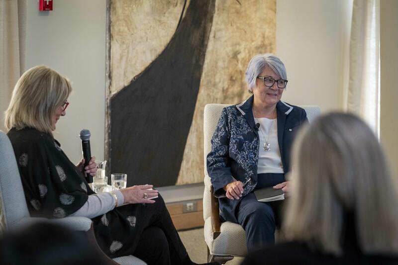 La gouverneure générale Mary Simon assise avec un petit groupe de personnes en pleine discussion. 