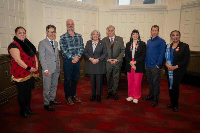 Governor General Simon and Mr. Whit Fraser are in the centre of a group of 8 people composed of men and women. Everyone is smiling to the camera.]