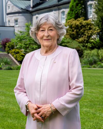 Photo officielle de la gouverneure générale Louise Arbour. Elle est à l'extérieur. Les jardins de Rideau Hall sont visibles à l'arrière-plan.