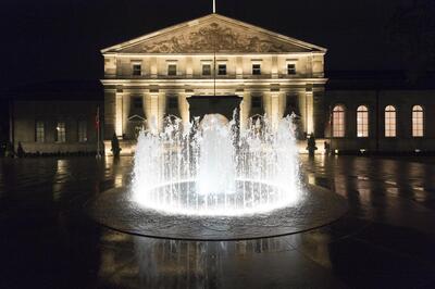 Exterior of Rideau Hall and fountain at night.