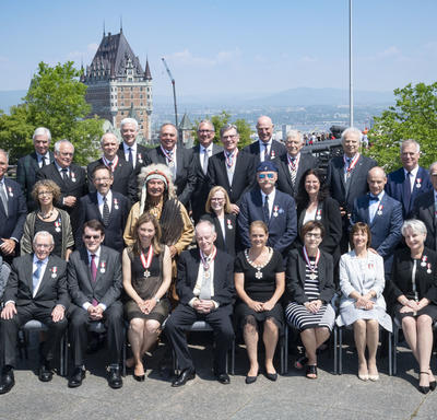 Newly invested members of the Order of Canada take a group photo with the Governor General.