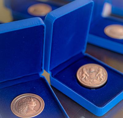 Three Governor General's Academic All-Canadian Commendation medal displayed in opened blue boxes on a table.