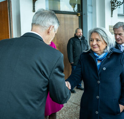 Governor General Simon shaking hands with Acting Chair of the City Council Harry Bogomoloff. Two people are standing behind them.
