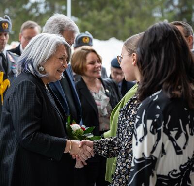 Governor General Simon shaking a student’s hand. There are other people around them. 