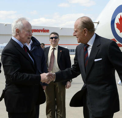 The Duke of Edinburgh shakes hands with Governor General David Johnston on the tarmac. 