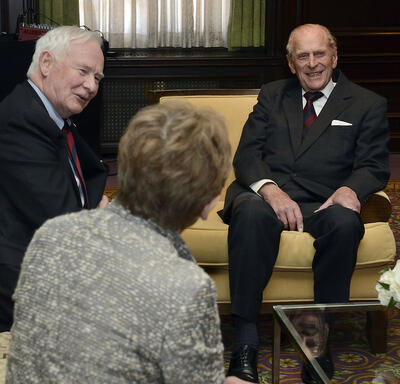 The Duke of Edinburgh is engaged in conversation with Governor General Johnston and Mrs. Sharon Johnston.