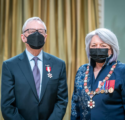 Derek Lister is standing next to the Governor General.