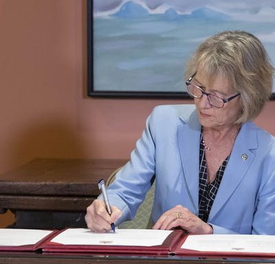 Minister Murray signs the oath book. 