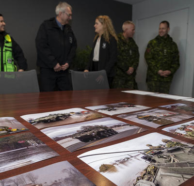 Des photos des efforts des Forces armées canadiennes pour contrer les inondations sont sur une table. 