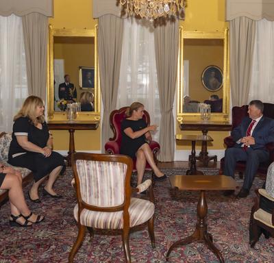 The Governor General, Her Honour the Honourable Antoinette Perry, Lieutenant Governor of Prince Edward Island, and the Honourable Dennis King, Premier of Prince Edward Island, sit and discuss with other delegates in a room inside Government House.